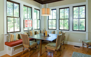A kitchen with a breakfast nook surrounded by large windows