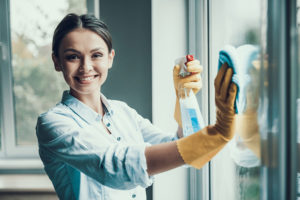 Woman smiling while cleaning a window.