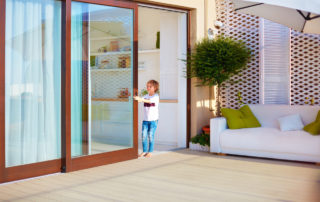 young boy opening the sliding door on rooftop patio area at home