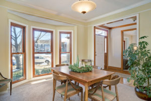 Full-length double-hung wood-grain windows in a dining room.